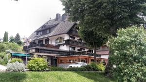 un grand bâtiment avec une voiture garée devant lui dans l'établissement Hochschwarzwald-Hof, à Schluchsee