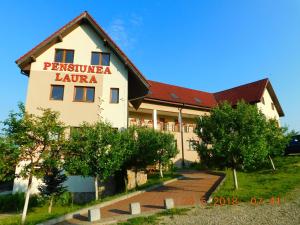 a building with a sign that reads pestaesta la latina at Pension Laura Cheile Turzii in Petreştii de Jos
