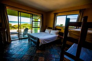 a bedroom with two beds and a view of the ocean at Island Vibe Jeffreys Bay in Jeffreys Bay