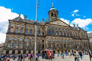 un gran edificio con gente caminando delante de él en Travel Hotel Amsterdam, en Ámsterdam