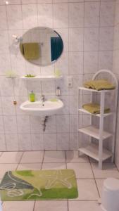 La salle de bains est pourvue d'un lavabo et d'un miroir. dans l'établissement Ferien- und Reiterparadies Voßhörnerhof, à Neuschoo