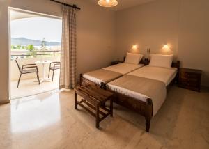 Merabello Apartments في أييا مارينا نيا كيذونياس: غرفة نوم مع سرير وبلكونة مع طاولة