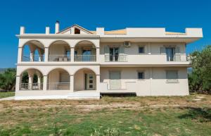a large white house on top of a field at Villa Penelope in Kalpaki