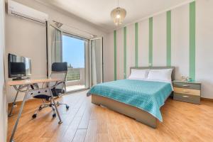 a bedroom with a bed and a desk and a computer at Villa Penelope in Kalpaki