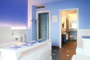 a room with blue walls and a hallway with beds at Hotel Palladio in Giardini Naxos