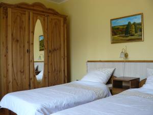 a bedroom with two beds and a mirror at Őrségi Gorza Vendégház in Nagyrákos