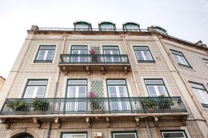 a tall brick building with windows and balconies at Contador Mor Rooms and Apartments in Lisbon
