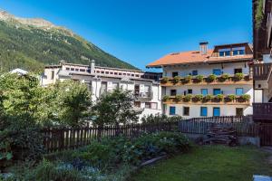 a building with a fence in front of a mountain at Hotel Stocker in San Valentino alla Muta