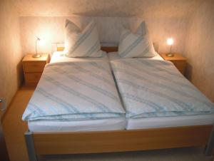 Una cama con dos almohadas encima. en Ferienwohnung Windten, en Braunlage