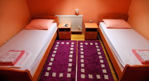 Duas camas num pequeno quarto com um tapete em Apartments Klanac em Osijek