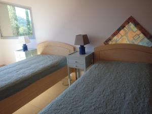1 dormitorio con 2 camas, mesita de noche y ventana en Cora Venez, en Saint-Bresson