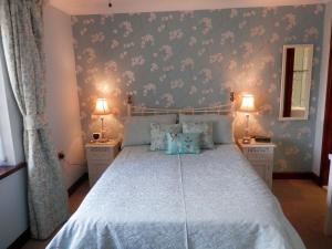 a bedroom with a large bed with blue and pink wallpaper at Finjaro in Sproughton