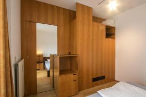 a bedroom with a large wooden wall with a mirror at Flataid Apartment Schießstattgasse in Graz