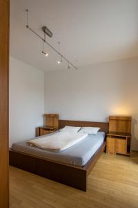 a bed in a room with a white wall at Flataid Apartment Schießstattgasse in Graz