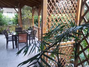 a wooden gazebo with tables and chairs and a plant at Georgievi Guest House in Sapareva Banya
