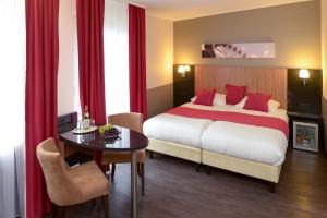 una camera d'albergo con letto e tavolo di Hotel Munich City a Monaco