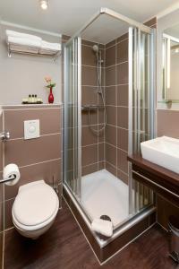 a bath room with a toilet and a bath tub at Hotel Munich City in Munich
