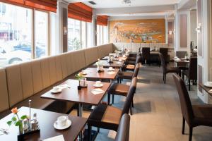eine Reihe von Tischen und Stühlen in einem Restaurant in der Unterkunft Hotel Munich City in München