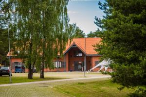 a building with a tree in front of it at Hotel Palanga Camping in Palanga