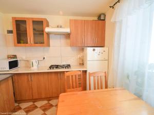 a small kitchen with wooden cabinets and a table at Kacperek in Jastarnia