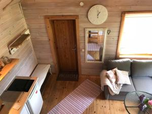 een woonkamer met een bank en een klok aan de muur bij Laasi Cozy Cottage in Kaigutsi