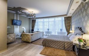 
a hotel room with a bed, chair, and nightstand at Victoria Plaza in Pereslavl-Zalesskiy
