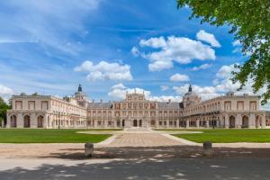a large building with a green lawn in front of it at Posada de la Costurera de Aranjuez in Aranjuez