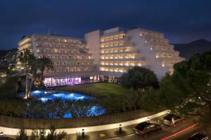 a large building with cars parked in front of it at Melia Sitges in Sitges
