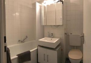 a bathroom with a sink and a toilet and a tub at Apartment Schwabing/Olympic Park/BMW in Munich