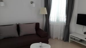 a living room with a couch and a window at Apartmani Vitturi in Kaštela