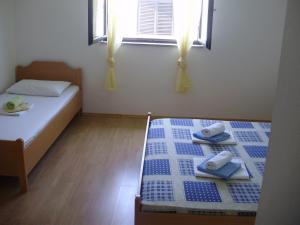 a bedroom with two beds with towels and a window at Villa Welcome in Vrboska