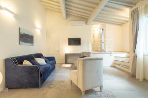 a living room with a blue couch and a chair at Carapelli Apartments in Florence