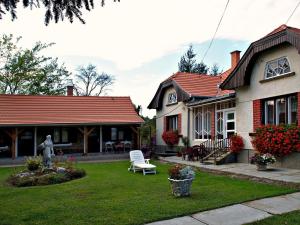 una casa con una estatua en el patio en Őrségi Gorza Vendégház, en Nagyrákos