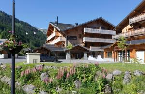 a building with a bunch of flowers in front of it at Résidence Néméa Le Grand Ermitage in Châtel