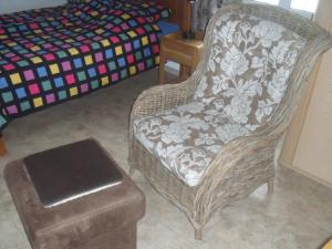 Lajes das FloresにあるCasa Biancaの籐の椅子とスツール付きのベッドルーム