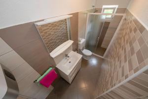 a bathroom with a sink and a toilet and a mirror at Apartman Jasmina in Banjol