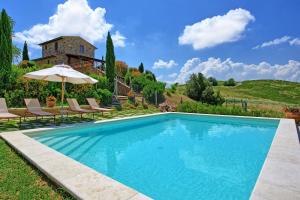 a swimming pool in front of a villa at Castelmuzio by PosarelliVillas in Castelmuzio