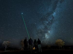 a group of people standing under the milky way at Lord Milner Hotel in Matjiesfontein