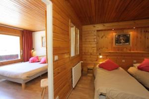 a room with two beds in a wooden cabin at Hotel le Sherpa in Les Deux Alpes