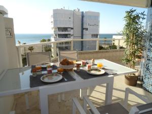 einen Tisch mit Essen auf einem Balkon mit Meerblick in der Unterkunft Residencia Pez Espada in Torremolinos
