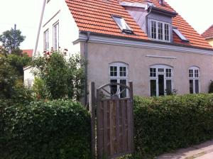 ein Tor zu einem Haus mit einem orangenen Dach in der Unterkunft Villa Valby in Kopenhagen