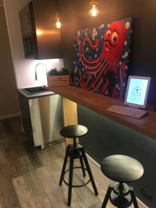 a kitchen with a counter with a laptop and two stools at Politeama Luxury Suites in Palermo