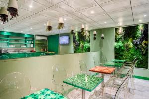 ein Restaurant mit grünen und orangefarbenen Tischen und Stühlen in der Unterkunft Jardins de Montmartre in Paris