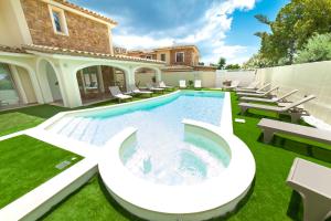 a pool in the yard of a house with chairs and a house at Suimi's Hotel in Villasimius