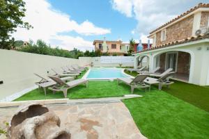 a backyard with chairs and a swimming pool at Suimi's Hotel in Villasimius