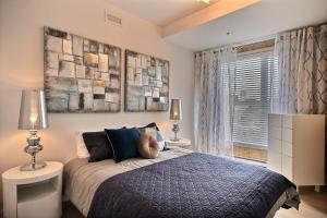 1 dormitorio con 1 cama, 2 lámparas y ventana en The Modern Cocoon, en Quebec