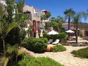 a resort with chairs and umbrellas in a courtyard at Eco Finca Vista Bonita in San Miguel de Abona