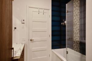 een badkamer met een witte deur naast een douche bij The Modern Cocoon in Québec +14 foto's
