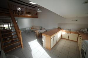 a kitchen with a staircase and a table in a room at Le Bois Tableau in Muron