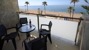 uma varanda com mesa e cadeiras e a praia em As Apartamentos Turisticos em Morche